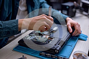 Closeup of engineer technician repairing faulty on laptop computer at work place