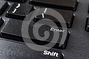 Closeup of enter key on a black computer keyboard. Distance learning, online work, business and shopping, confirm product order or