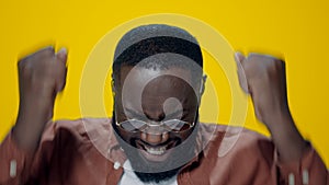 Closeup excited african american guy showing yes gesture on yellow background.