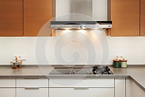 Closeup of exhaust hood and ceramic cooking plate in the new modern kitchen.