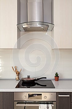 Closeup of exhaust hood and ceramic cooking plate in the new modern kitchen.