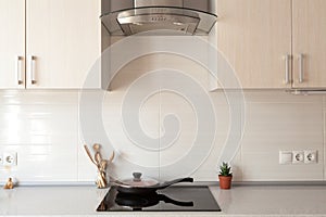 Closeup of exhaust hood and ceramic cooking plate in the new modern kitchen.