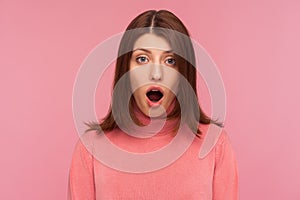 Closeup extremely shocked bemused brunette woman looking at camera with big eyes and widely opened mouth, deeply impressed