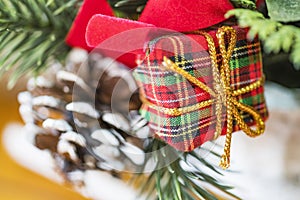 Closeup of fabric wrapped holiday gift with red bow gold twine a