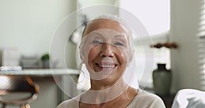 Closeup face of 65s happy elderly woman looking at camera