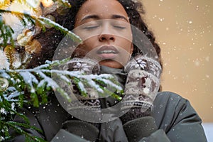 Closeup face of African girl. Beautiful young woman in warm winter knitted clothes with closed eyes