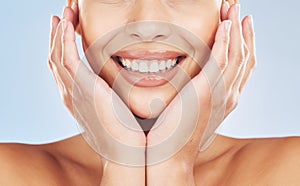 Closeup face beautiful young mixed race woman. Attractive female smiling in studio isolated against a blue background