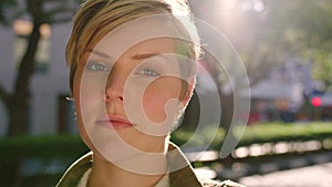 Closeup face of fashionable woman showing cheerful facial expression in city. Portrait of young, trendy or shy lady