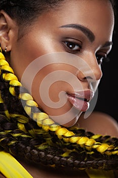 Closeup face fith yellow braids. Portrait of an African American Black Woman.