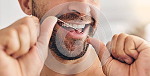 Closeup, face and man flossing teeth at home for healthy dental wellness, plaque and gingivitis. Happy guy, oral thread
