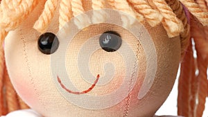 Closeup face rag doll smiling on a white background