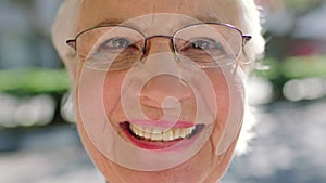 Closeup face of a senior woman wearing glasses and laughing while out in the city. Portrait of a playful elderly lady