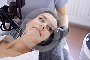 young woman undergoing laser resurfacing and peeling procedure photo