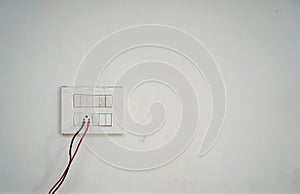 Closeup of a faceplate with cable wires mounted on a white wall