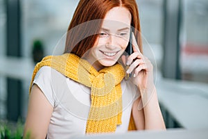 Closeup facial portrait of happy redhead woman on mobile phone call