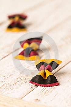 Closeup of Farfalle pasta on white wooden background.