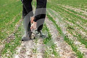 Closeup of farmer`s hands, hoe and field in spring. The concept of the garden, the beginning of the season, summer cottage