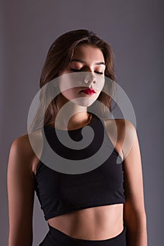 Closeup fashion portrait of sensuous woman looking down on gray background