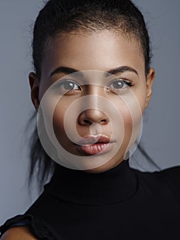 Closeup fashionable portrait of a beautiful african american female model with nude fresh makeup