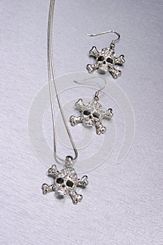 Closeup of fashionable skull and crossbones necklace set photo