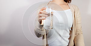 Closeup fat woman holding drinking water glass in her hand