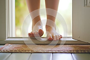 closeup of feet stepping over threshold