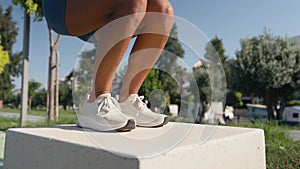 Closeup of female athlete doing jump training outdoors, fatburning plyometric exercise