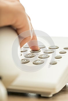 Closeup of female businessmperson dialing a telephone number on