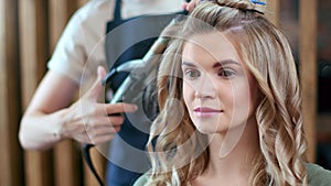 Closeup female client of fashion salon during creating hairstyle. Shot on RED Raven 4k Cinema Camera