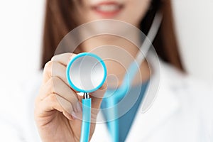 Closeup of female doctor`s hand holding a stethoscope to auscultate