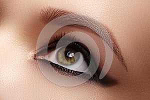 Closeup Female Eye with Dark Make-up, great Shapes Brows. Celebrate Makeup, Luxury Eyeshadows. Fashion Eyeliner, pencil photo