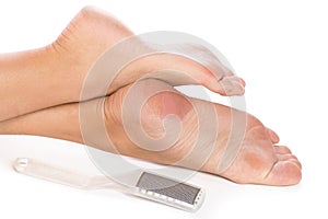 Closeup of female feet and callus remover tool