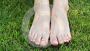 Closeup of a female feet with white french pedicure on nails