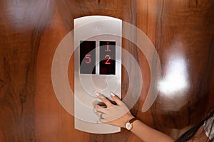 Female finger pushing elevator button
