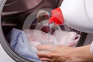 Closeup of a female hand detergent or washing liquid in the container