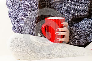 Closeup female hand holding red mug hot drink