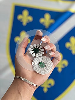 Closeup of a female hand holding Srebrenica Flowers symbolizing the Srebrenica genocide