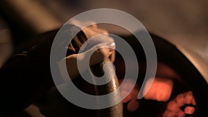 Closeup of a female hand holding the steering wheel driving a car on a country road at night. Shallow depth of field