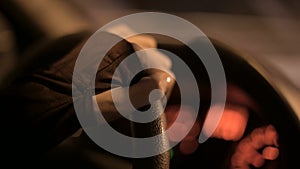 Closeup of a female hand holding the steering wheel driving a car on a country road at night. Shallow depth of field