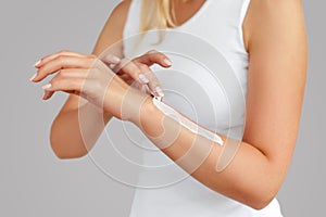 Closeup of female hands applying hand cream.Hand Skin Care. Women use body lotion on your arms. Beauty And Body Care Concept.