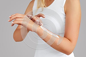 Closeup of female hands applying hand cream.Hand Skin Care. Women use body lotion on your arms. Beauty And Body Care Concept. photo