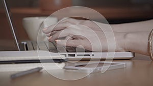 Closeup of a female hands busy typing on a laptop.