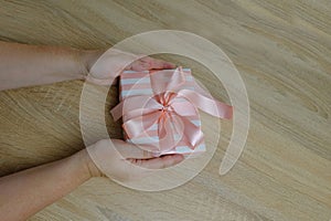 closeup female hands holding box with gift, bouquet of white, pink roses, box with gift with satin ribbon, flowers for