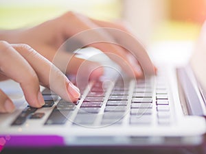 Closeup female hands typing on laptop keyboard.