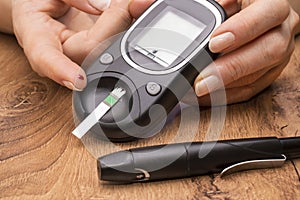 Closeup female hands using glucometer scanner