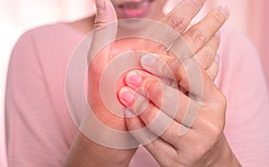 Closeup of female holding her painful palm and numbness caused by prolonged work on the computer or housewife, Carpal tunnel