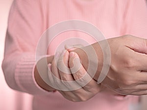 Closeup of female holding her painful wrist caused by prolonged work on the computer or housewife, Carpal tunnel syndrome,
