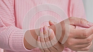 Closeup of female holding her painful wrist caused by prolonged work on the computer or housewife, Carpal tunnel syndrome, arthrit