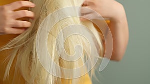 Closeup female holding messy hair in hands. Daily preparation for looking nice, Long Disheveled Hair. hair problems from