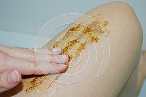 Closeup of female legs with coffee scrub. Cosmetology, spa, beauty concept